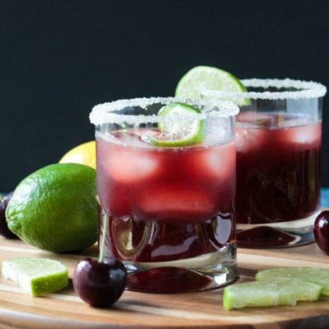 Two Tart Cherry Sparkling Lemonade in low ball glasses with black background.