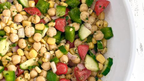 Cilantro lime chickpea salad in a white bowl on white wood countertop
