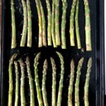 Sheet pan of perfectly roasted asparagus stalks.