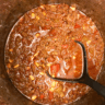 Keto chili simmering in a pot with black ladle