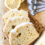 Overhead photo of wooden cutting board with three slices of lemon loaf drizzled with a white lemon icing
