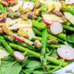 This delicious recipe features a variety of vibrant greens, tender asparagus, and crisp radishes, all tossed in a light and flavorful dressing and topped with pistachios and shaved parmesan cheese. Perfect as a light lunch or side dish, this salad is sure to impress!