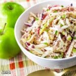 A refreshing apple coleslaw in a pristine white bowl, beautifully contrasting with a vivid, patterned napkin.