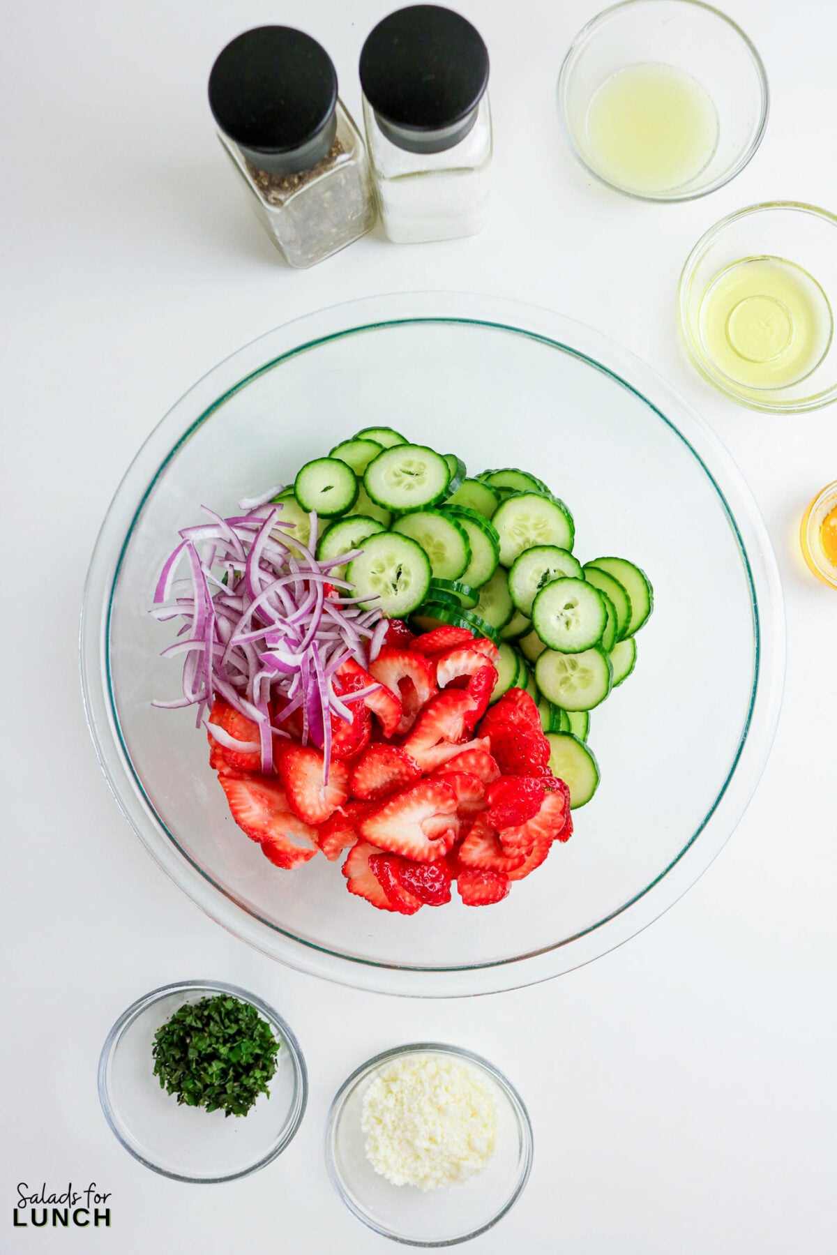 Strawberry Cucumber Salad ingredients in a bowl: strawberries, cucumber, red onion.