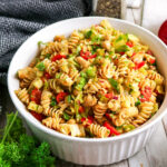 Healthy rotini pasta salad with chickpeas, cucumber, tomatoes, and red bell pepper.