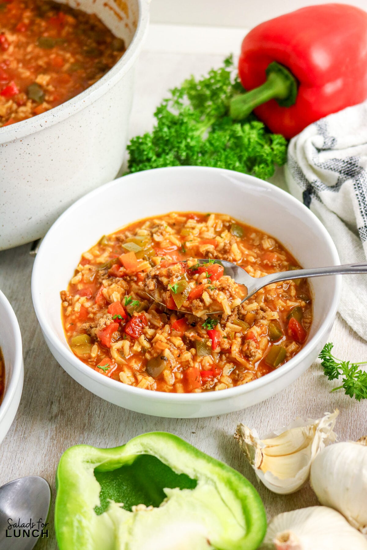 Bowl of stuffed pepper soup with ground beef, rice, and vegetables.