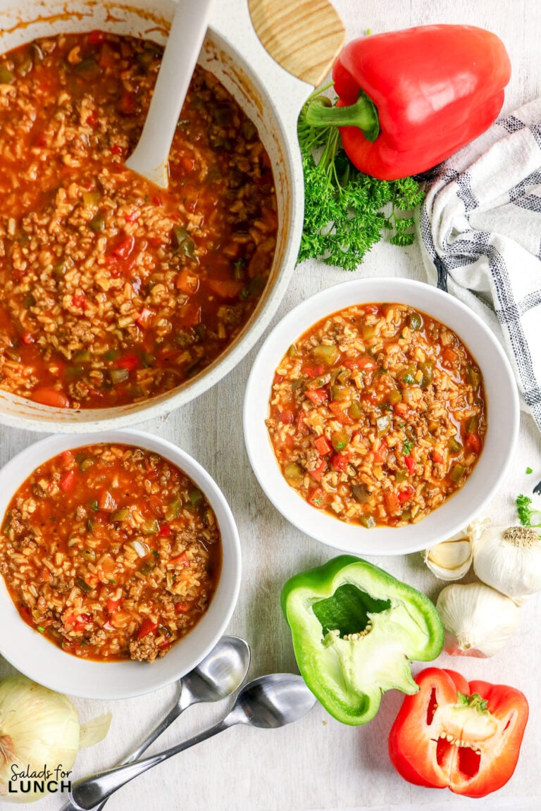 Stuffed pepper soup in bowls and pot with peppers and garlic.