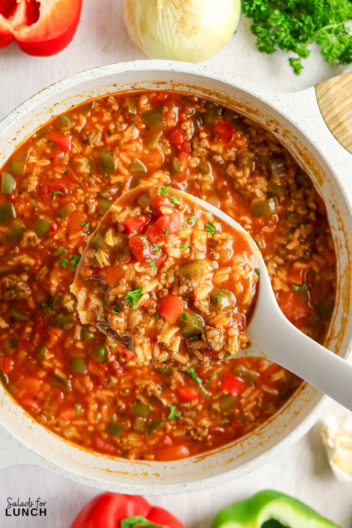 Stuffed pepper soup in a pot with a spoonful lifted.