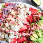 Strawberry avocado chicken salad with bacon, blue cheese, and red onion drizzle.