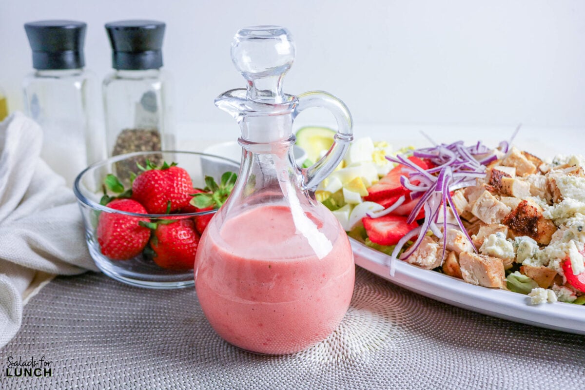 Strawberry Chicken Cobb Salad with Creamy Strawberry Vinaigrette - strawberry vinaigrette chicken salad 1 Strawberry vinaigrette in a glass cruet with a chicken salad.