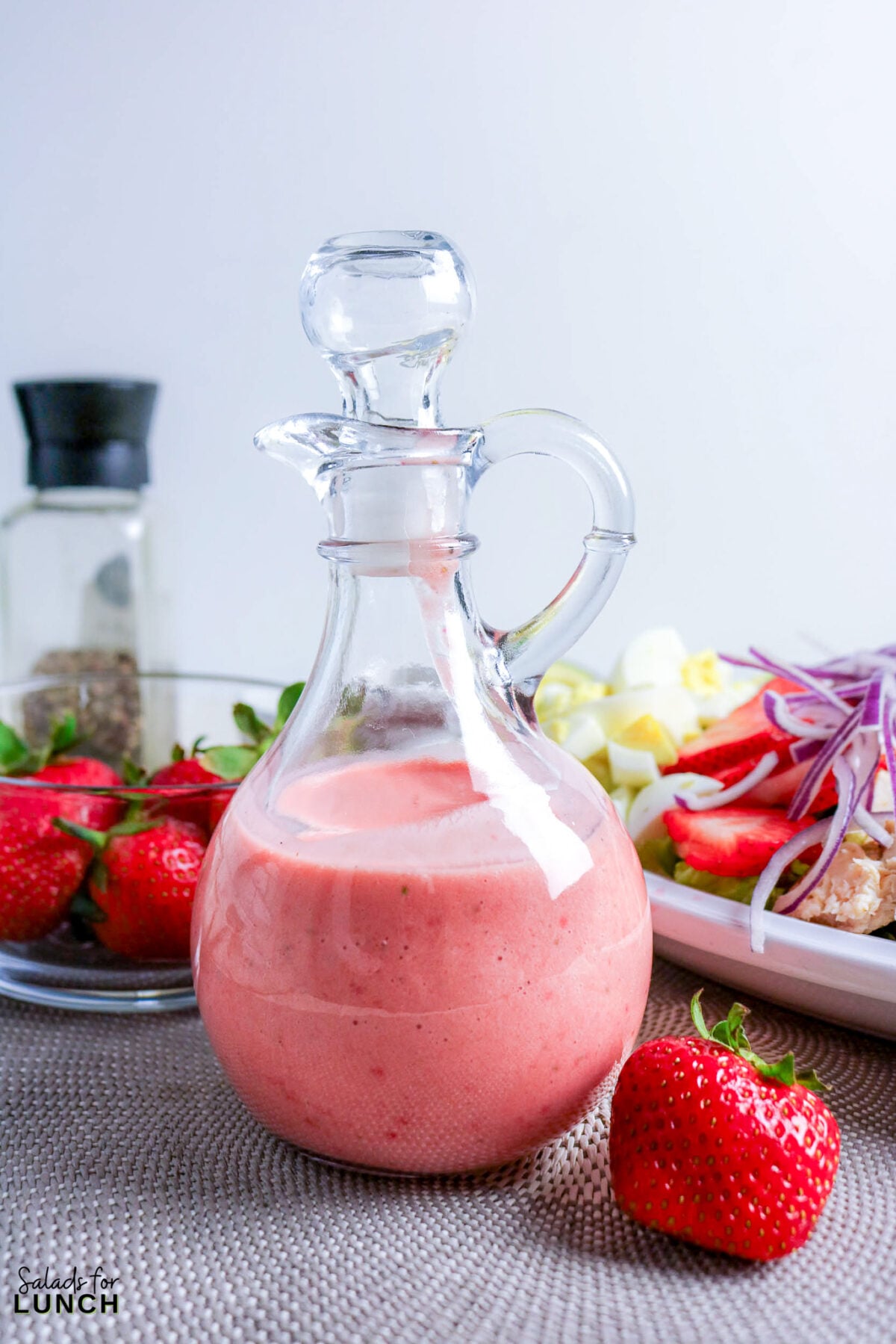 Strawberry Chicken Cobb Salad with Creamy Strawberry Vinaigrette - strawberry vinaigrette cruet salad strawberries Strawberry vinaigrette in a glass cruet with fresh strawberries and salad