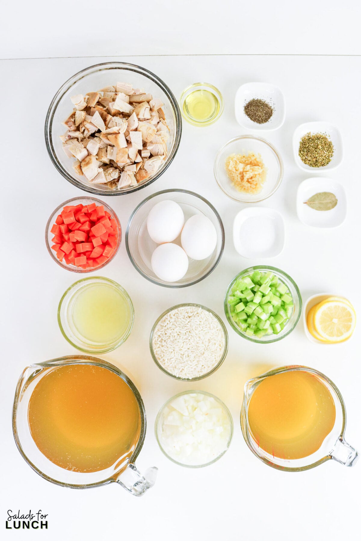 Greek Lemon Chicken and Rice Soup (Easy Avgolemono Recipe) - Greek Lemon Chicken Soup Ingredients All ingredients for Greek Lemon Chicken and Rice Soup laid out: shredded chicken, eggs, diced carrots, celery, onion, rice, chicken broth, lemon juice, garlic, olive oil, oregano, bay leaf, and salt and pepper.