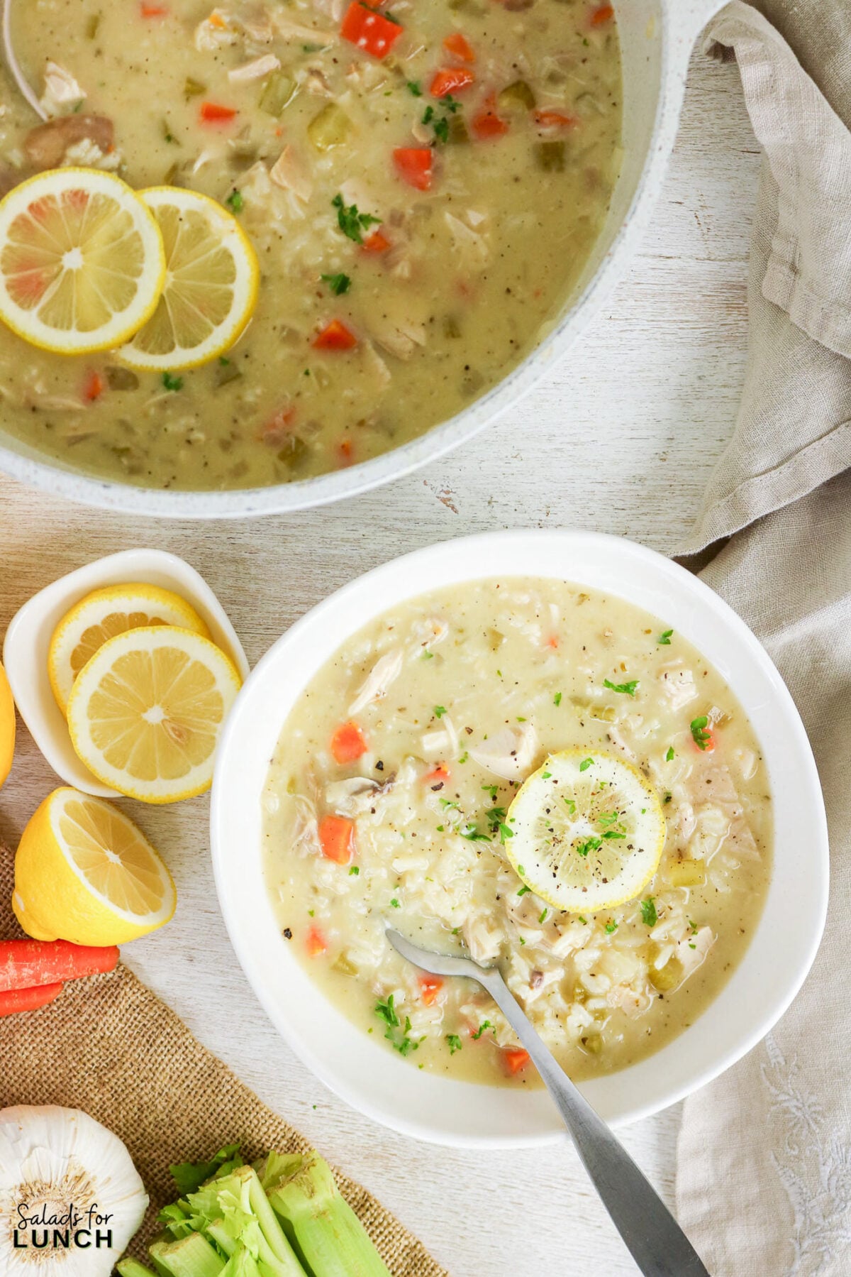 Greek Lemon Chicken and Rice Soup (Easy Avgolemono Recipe) - Greek Lemon Chicken Soup with Rice Recipe 16 Creamy Greek chicken and rice soup with carrots, celery, and mushrooms, garnished with a lemon slice and fresh parsley,