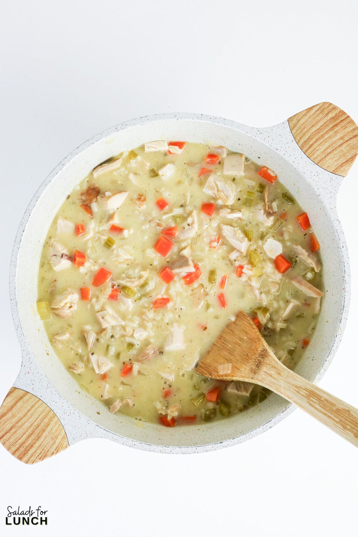 Greek Lemon Chicken and Rice Soup (Easy Avgolemono Recipe) - Greek Lemon Chicken Soup with Rice Recipe 27 Silky egg-lemon broth stirred into the pot of Greek lemon chicken and rice soup with a wooden spoon.