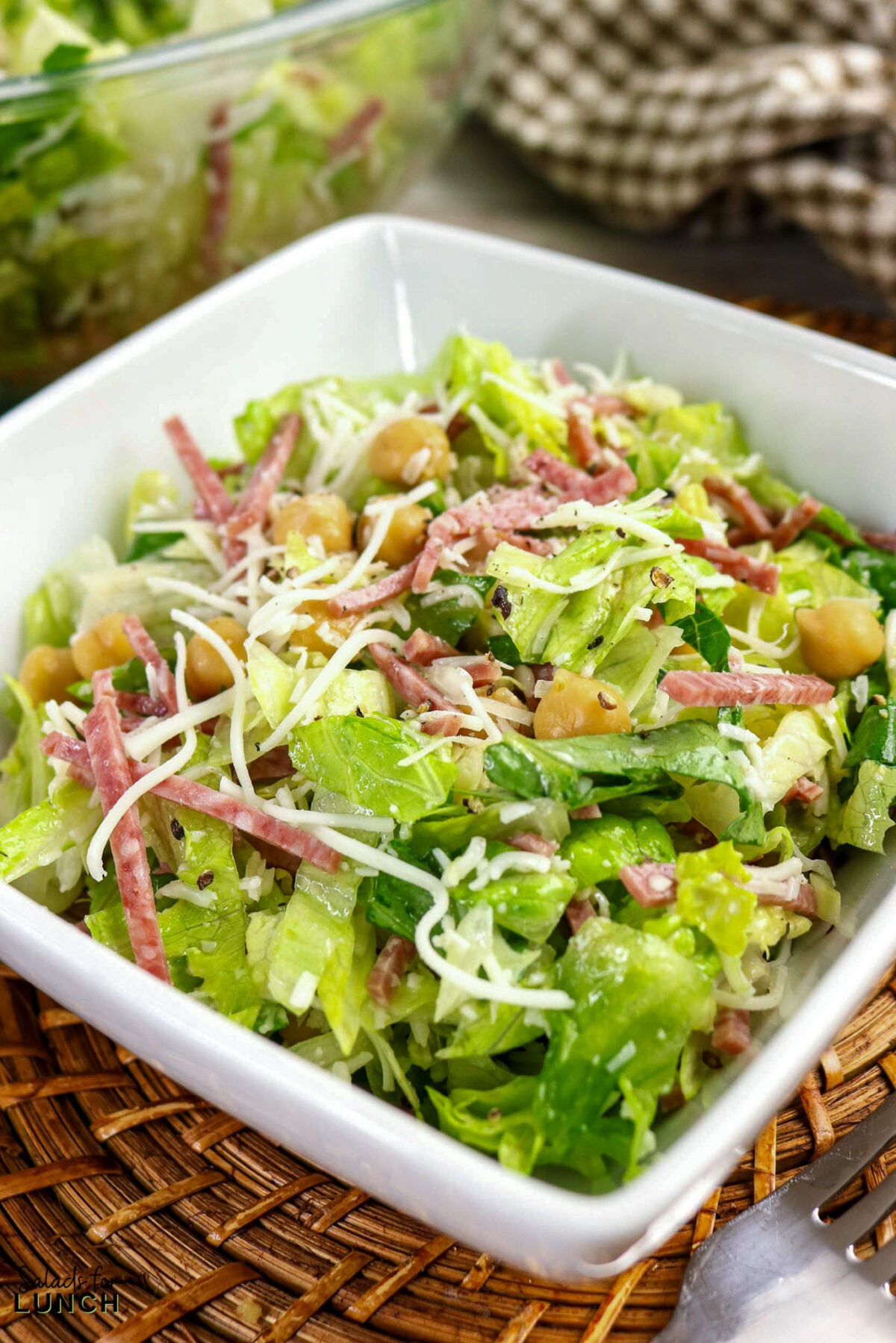 La Scala Chopped Salad Recipe (Easy Beverly Hills Copycat) - La Scala Italian Chopped Salad 07 Chopped Italian salad with romaine lettuce, salami strips, chickpeas, and shredded mozzarella in a white square bowl.