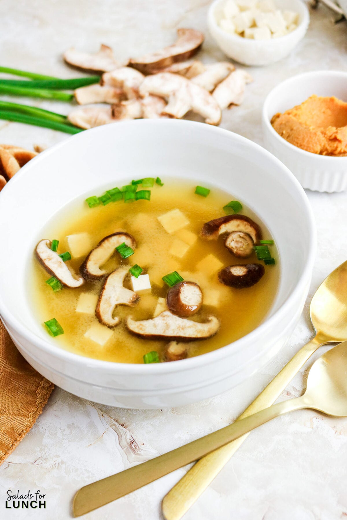 Easy Miso Soup with Mushrooms - Miso Soup Recipe With Mushrooms 11 Bowl of miso soup with shiitake mushrooms, tofu cubes, and sliced green onions in a golden savory broth.