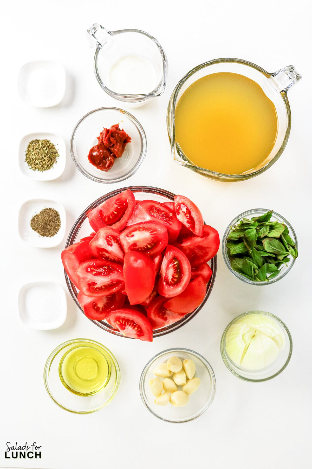 Ingredients for roasted tomato basil soup: quartered tomatoes, broth, basil, onion, garlic, olive oil, tomato paste, cream, and seasonings.