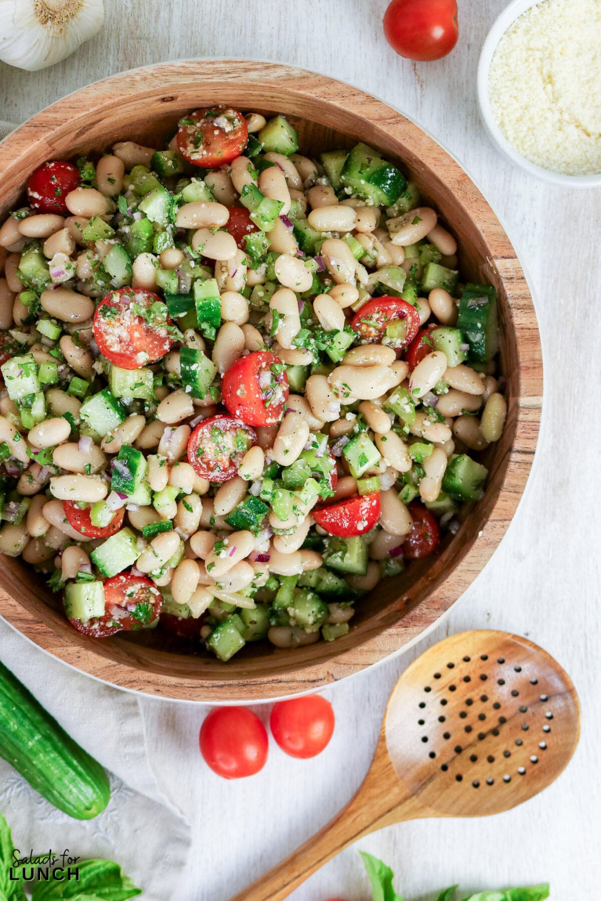 Easy Tuscan Bean Salad - Tuscan Bean Salad Hero 24 Tuscan bean salad with cannellini beans, halved cherry tomatoes, diced cucumber, red onion, and fresh herbs in a wooden bowl.