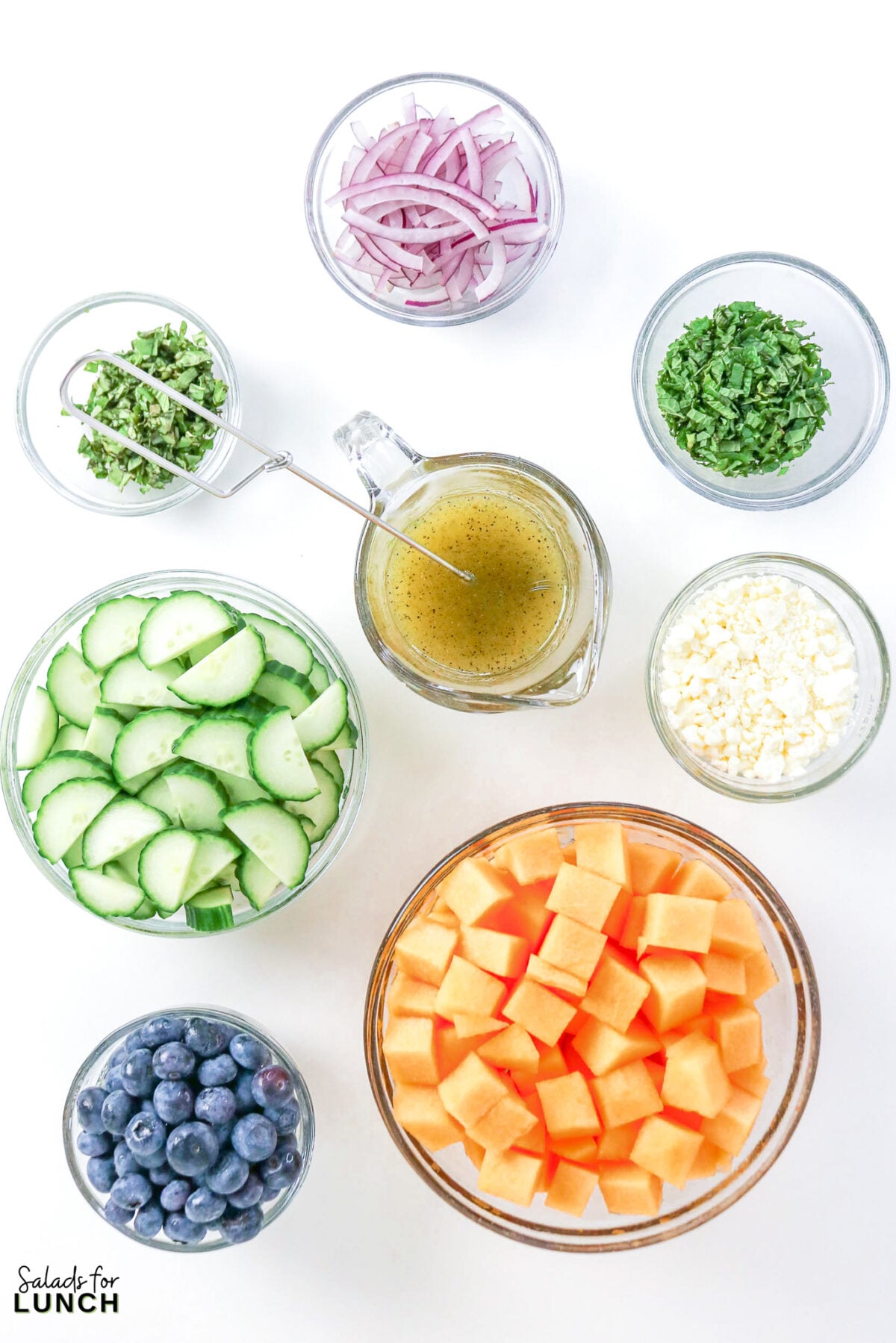 Cantaloupe Cucumber Feta Salad - Cantaloupe Salad Process 6 Bowls of cubed cantaloupe, sliced cucumber, blueberries, feta, red onion, mint, basil, and whisked honey lime dressing.