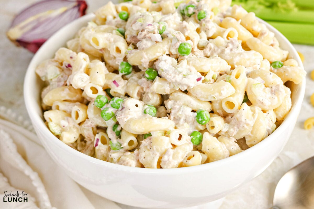 Creamy Tuna Macaroni Salad - Tuna Macaroni Salad Hero 15 Bowl of creamy tuna macaroni salad with elbow pasta, peas, red onion, and celery.