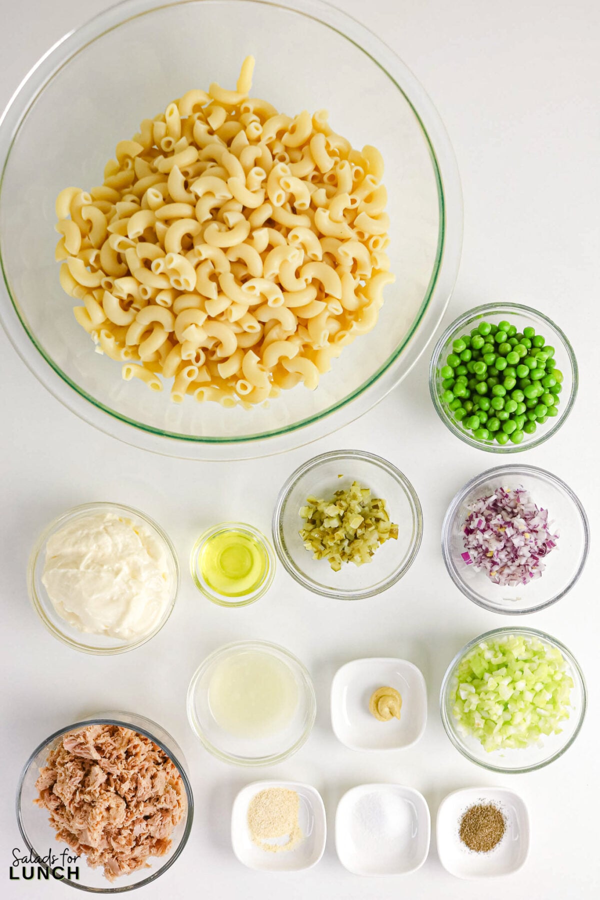 Creamy Tuna Macaroni Salad - Tuna Macaroni Salad Ingredients Ingredients for tuna macaroni salad arranged in bowls: cooked macaroni, peas, mayonnaise, oil, relish, red onion, celery, vinegar, mustard, tuna, and seasonings.
