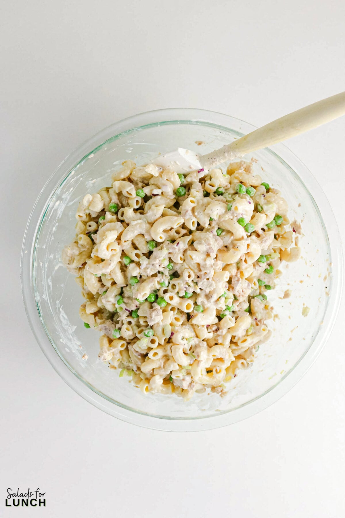 Creamy Tuna Macaroni Salad - Tuna Macaroni Salad Process 2 Tuna macaroni salad with peas, celery and red onion mixed in creamy dressing in a glass bowl.