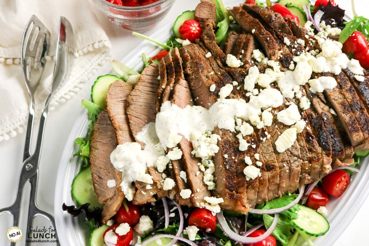 Homemade Blue Cheese Dressing - Steak Salad Bluecheese Dressing 02 Sliced grilled steak salad with mixed greens, cherry tomatoes, cucumbers, red onion, blue cheese crumbles, and creamy homemade Blue Cheese salad dressing.