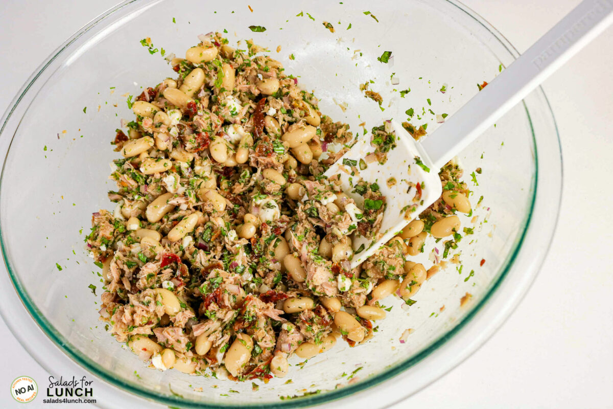 Tuscan Tuna Salad - Tuscan Tuna Salad Process 03 Tuna, cannellini beans, herbs, sun-dried tomatoes and goat cheese tossed together in a glass bowl.