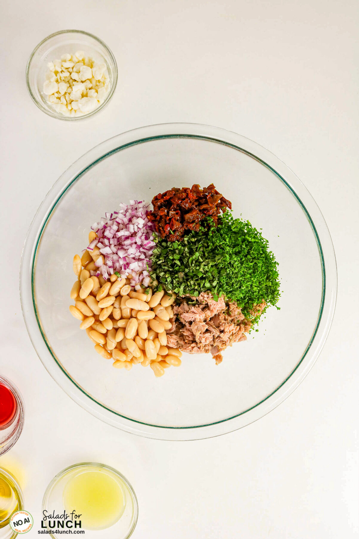 Tuscan Tuna Salad - Tuscan Tuna Salad Process 12 Bowl with white beans, tuna, chopped parsley, sun-dried tomatoes, and red onion, with feta and dressings alongside.